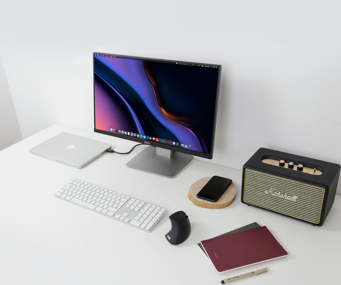 Moderne bureau-opstelling met laptop, monitor, toetsenbord en luidspreker.